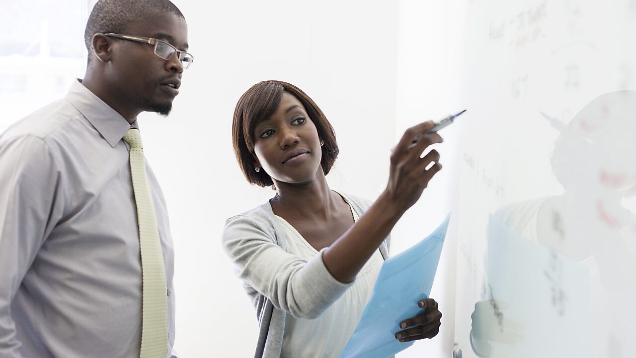 African business colleagues writing on the whiteboard